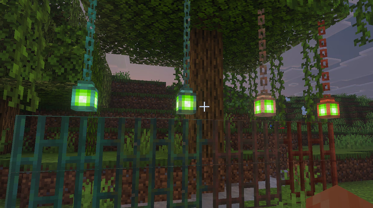 Colorful hanging lanterns decorating a forest path in Minecraft