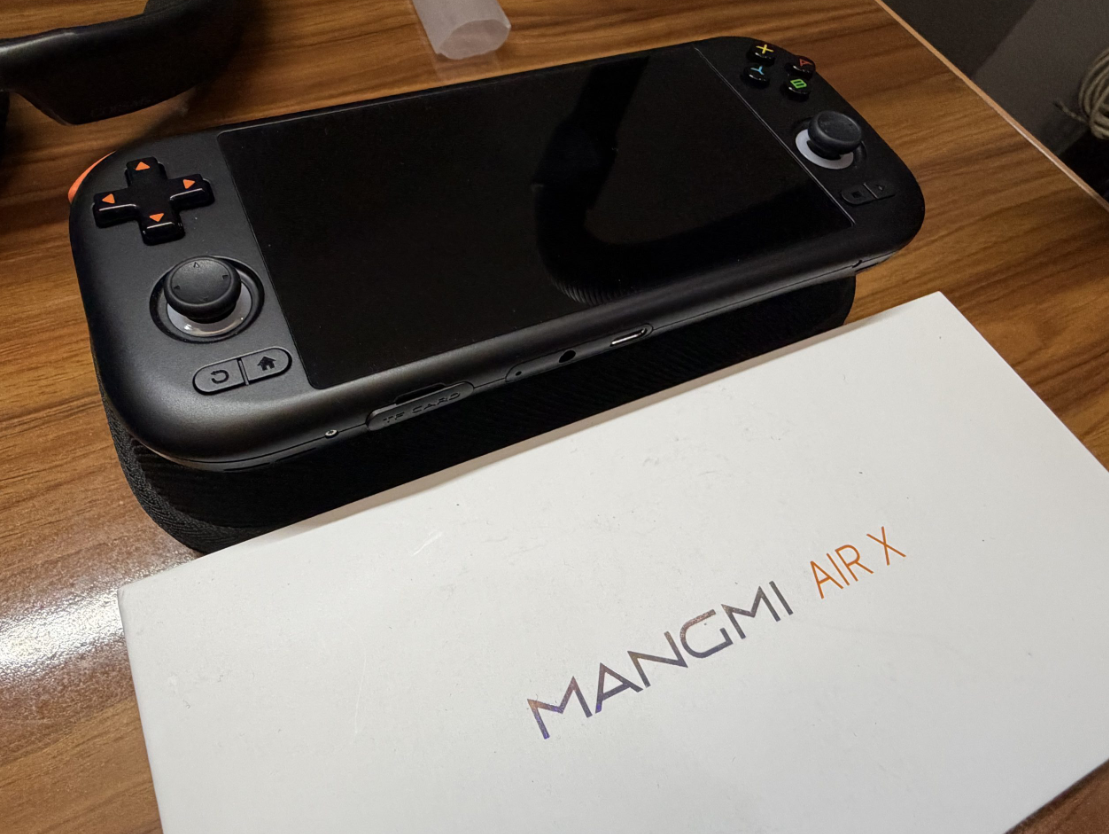 The Mangmi Air X handheld gaming console next to its retail box